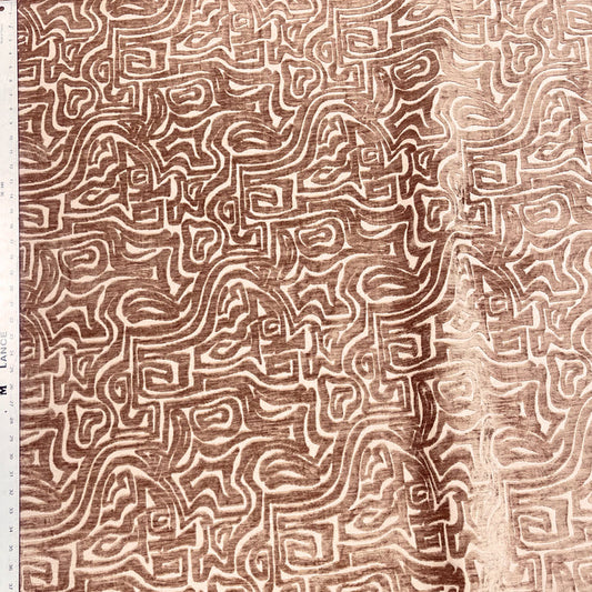 Textile with intricate brown pattern on a beige background